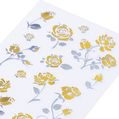 Goldene und silberne Rosenaufkleber auf weißem Hintergrund, angeordnet in verschiedenen Größen und Positionen.