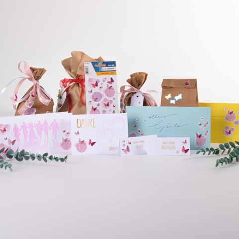 Geschenktüten und Karten in verschiedenen Farben und Designs, darunter eine "Danke"-Karte und eine "Alles Gute"-Karte, dekoriert mit Schmetterlingen.