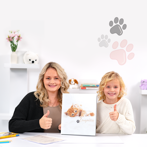 Eine Frau und ein Kind zeigen Daumen hoch, während sie ein Katzenbuch halten. Im Hintergrund sind Pfotenabdrücke und Dekorationen sichtbar.