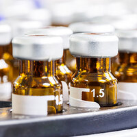 Etiketten in Rundbeklebung auf braunen Arzneimittel Fläschchen