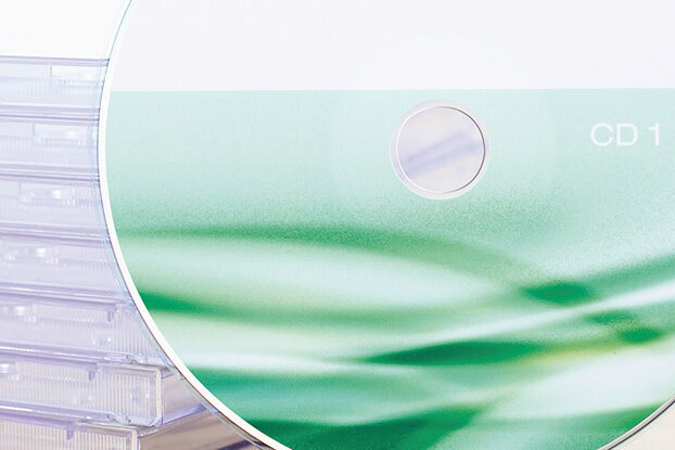 Hinweise zur Druckdatenübermittlung, CD vor einem Stapel mit Jewelcases, Querformat