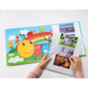 Ein offenes Bilderbuch mit bunten Illustrationen von Insekten und Blumen, daneben werden Fotos von Kindern in einem Album betrachtet.