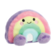 Buntes, kuscheliges Regenbogen-Kissen mit lächelndem Gesicht und runden, lila Pompons an den Enden.
