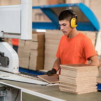Mitarbeiter an einer Säge in der Möbelproduktion