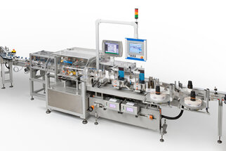 Automatisierte Produktionslinie mit Maschinen zur Verarbeitung und Verpackung von Produkten, ausgestattet mit Monitor und Steuerungselementen.