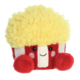 Plüschfigur eines Popcornbehälters mit gelbem, lockigem Oberteil und roten Seiten, lächelnd und freundlich gestaltet.