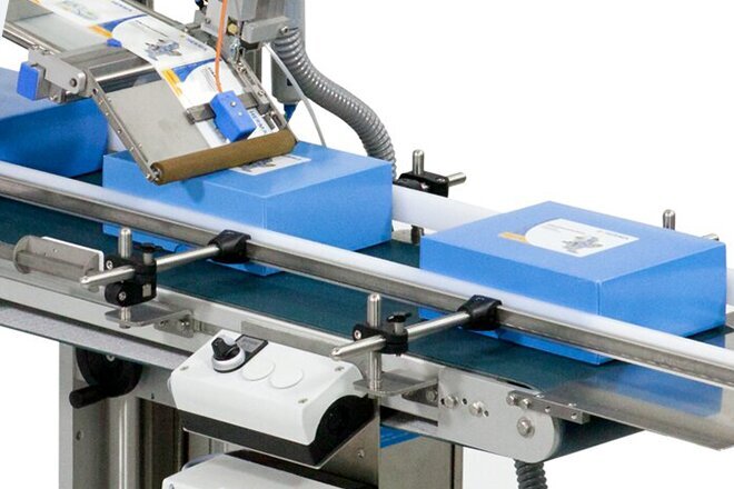 Eine Verpackungsmaschine mit blauen Kartons auf einem Förderband, die für die Automatisierung von Verpackungsprozessen verwendet wird.