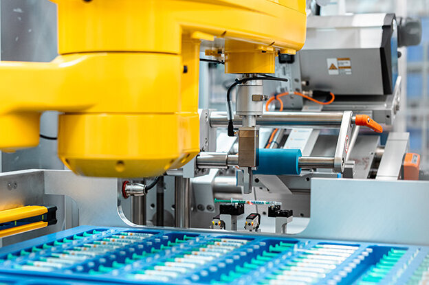 Industrieroboter mit zwei verschiedenen Modellen, einer auf einem Tisch und der andere an einer Montageeinheit, umgeben von technischen Grafiken.