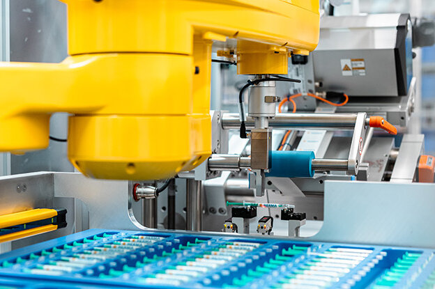 Industrieroboter mit zwei verschiedenen Modellen, einer auf einem Tisch und der andere an einer Montageeinheit, umgeben von technischen Grafiken.
