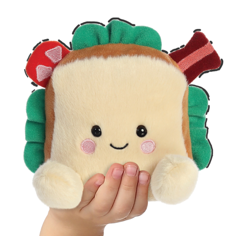 Ein kuscheliges Sandwich-Plüschtier mit einem lächelnden Gesicht, bunten Zutaten und einer Hand, die es hält.
