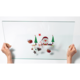 Eine transparente Glasplatte wird von zwei Händen gehalten, dekoriert mit Weihnachtsmotiven wie einem Schneemann, Tannenbäumen und Geschenken.