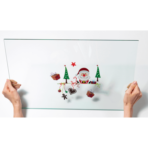 Eine transparente Glasplatte wird von zwei Händen gehalten, dekoriert mit Weihnachtsmotiven wie einem Schneemann, Tannenbäumen und Geschenken.