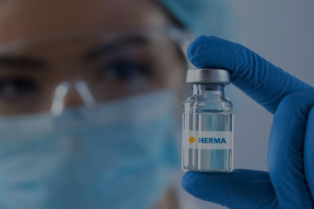 Eine Person in Schutzkleidung hält eine Impfstoffflasche mit dem Etikett "China" in der Hand.