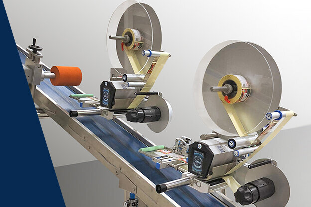 Eine industrielle Maschine mit zwei großen Rollen und einem Förderband, das für die Verarbeitung oder den Transport von Materialien ausgelegt ist.