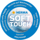 Rundes Logo mit dem Text "HERMA SOFT TOUCH", das auf weiche Haptik, Elastizität und den Verzicht auf Weichmacher hinweist.