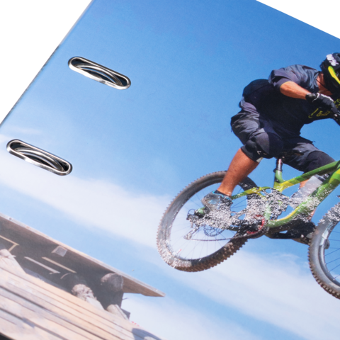 Ein Radfahrer springt mit einem Mountainbike über einen Hügel, während er in der Luft schwebt.