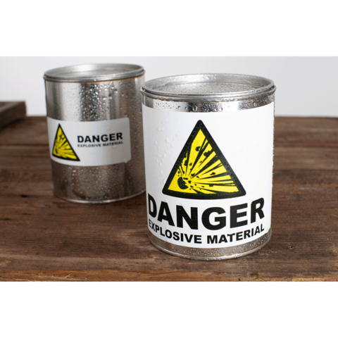 Metallbehälter mit Warnaufkleber für explosive Materialien, gekennzeichnet mit einem gelben Gefahrensymbol und dem Wort "DANGER".