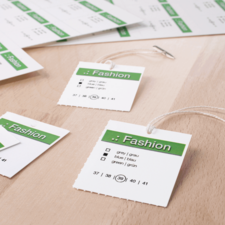 Modeetiketten mit Größenangaben (37, 39, 40, 41) und Farbauswahl (grau, blau, grün) auf einem Holztisch.