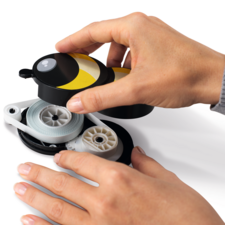 Eine Hand hält einen gelben und schwarzen Abroller, während eine andere Hand die Schnur herauszieht.